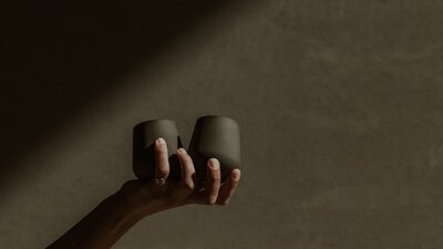 Ceramic tumblers by Madeline Cardone (STUDIO VESSL) A hand holding 2 ceramic tumblers by Madeline Cardone (STUDIO VESSL)