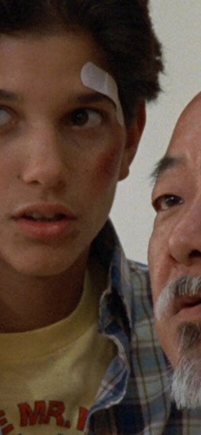 Still from The Karate Kid showing a man counselling a boy