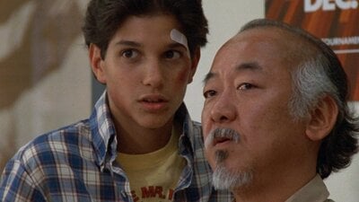 Still from The Karate Kid showing a man counselling a boy