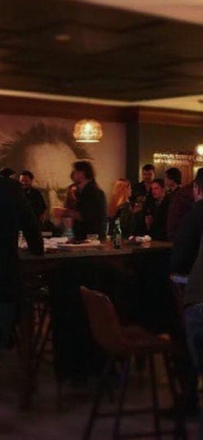 People standing at the bar talking