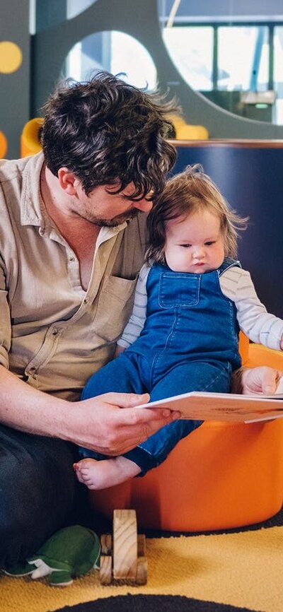 Dad reads to her young daughter