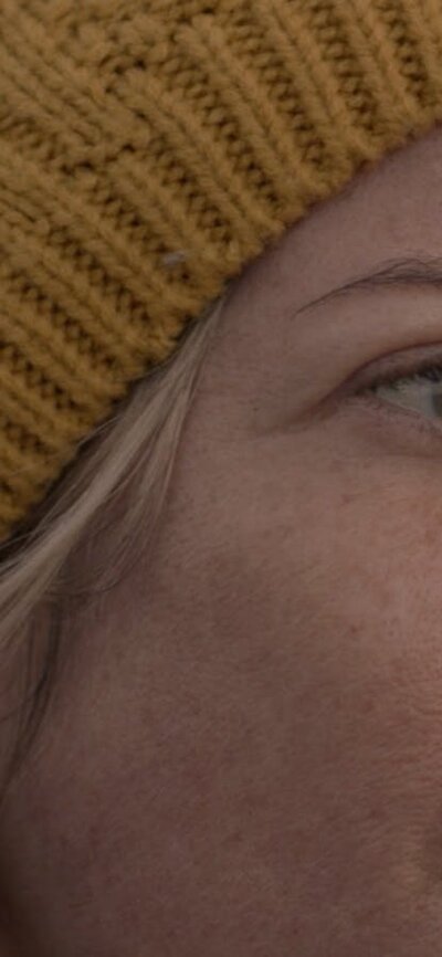 close up of woman looking to the side wearing a beanie
