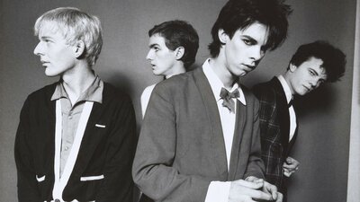 The Boys Next Door, 1978 Michel Lawrence. © Michel Lawrence A monochrome photographic portrait of four men with candid expressions wearing suits.