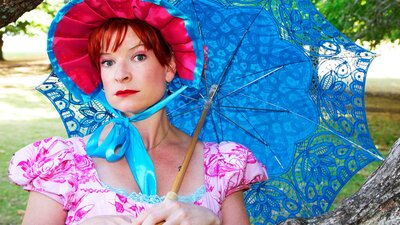 WOman dressed in Jane Austen style costume leaning on a tree