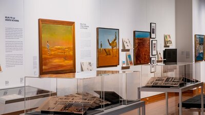 View of multiple Sidney Nolan paintings and vitrines with articles on Nolan