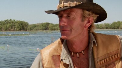 Man wearing an akubra with eyes closed, water in background