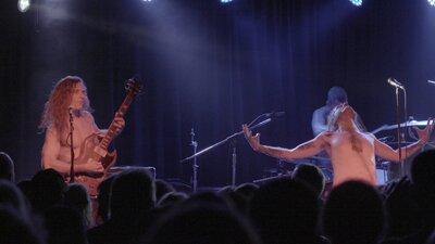 Still of band members playing on stage at a concert