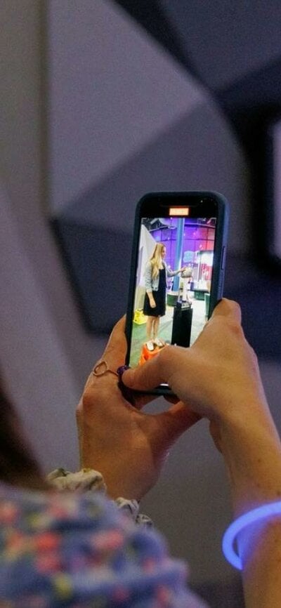 A woman taking a photo of her friend at Questacon After Dark