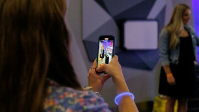 A woman taking a photo of her friend at Questacon After Dark