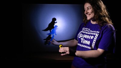 A woman making a dinosaur shadow in Science Time