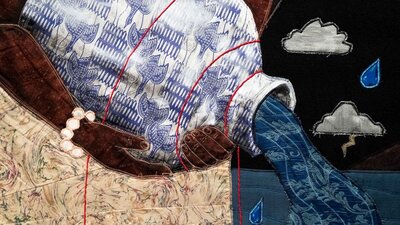 Close up of quilted textile artwork, showing a woman holding a water vessel