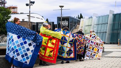 Canberra Quilters posing with quilts displayed at Civic Square