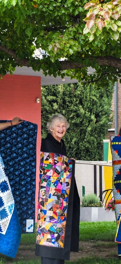 Canberra Quilters posing with quilts displayed at Civic Square
