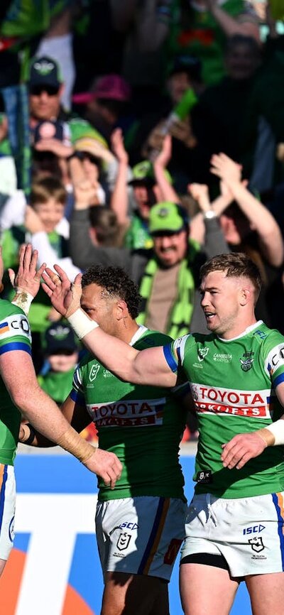 Canberra Raiders players and fans celebrate a try.