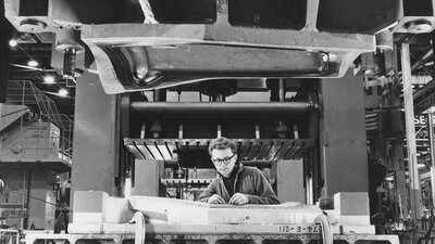 Black and white photograph of a man working in a mechanic workshop for Holden