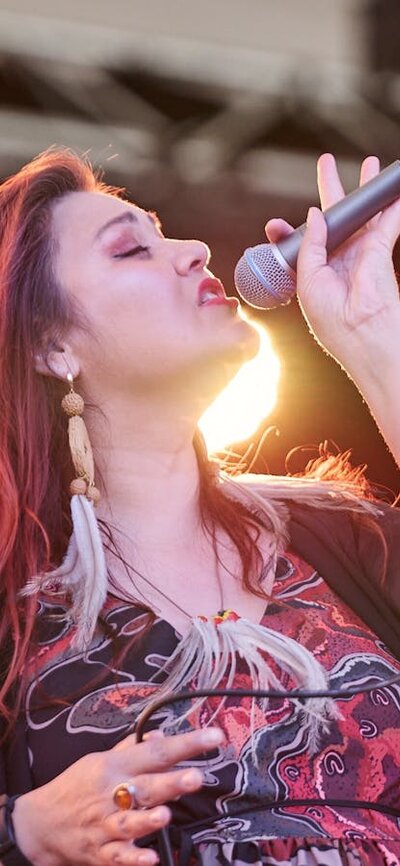 Person singing on stage with a microphone