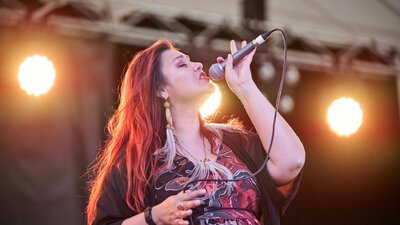 Person singing on stage with a microphone