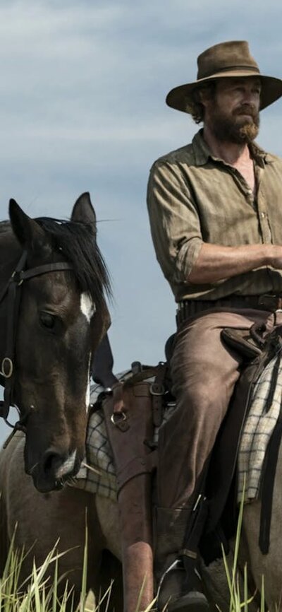 Two men on horseback in a field