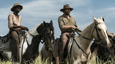 Two men on horseback in a field