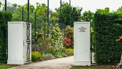 An outdoor area with the words "Old Parliament House Gardens"