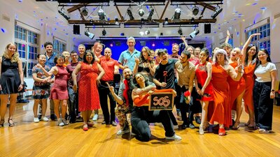 A group of social dancers dressed in for a photo following a dance workshop