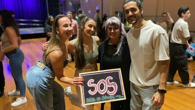 SOS X MoveMe with guest instructors.- 4 people holding the SOS blackboard.