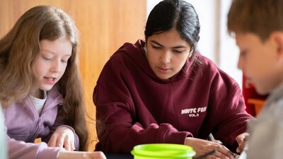 Three kids working on crafting activities