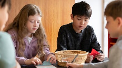 Children seated at a table doing craft activities