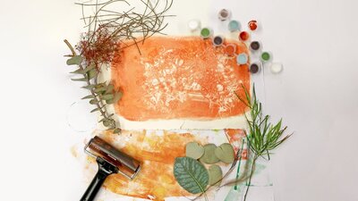 Colourful gel print and various implements used for gel print making