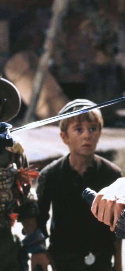 Hook (1991) A pirate points a sword at a scared man with scared children in background