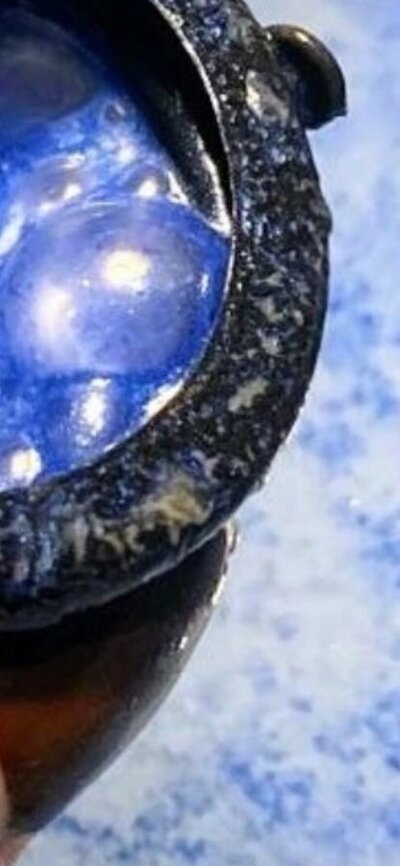 A bath bomb in cauldron, fizzing blue in the bath