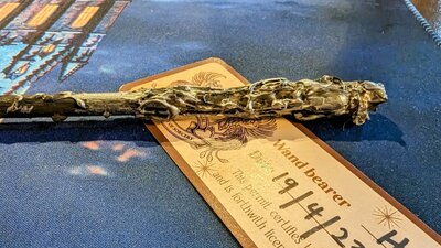 Photo of a handmade wand on a table with a completed wand license.