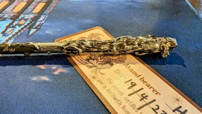 Photo of a handmade wand on a table with a completed wand license.