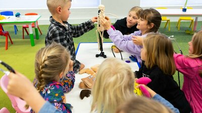 A group of children exploring a miniature skeleton A group of children exploring a miniature skeleton