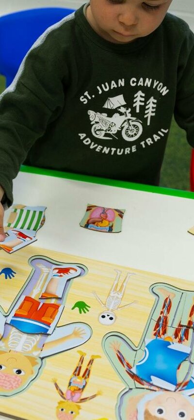 A young boy completing a human body puzzle at Science Time A young boy completing a human body puzzle