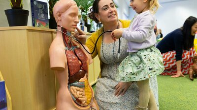 A young girl and woman exploring a human dummy A young girl and woman exploring a human dummy
