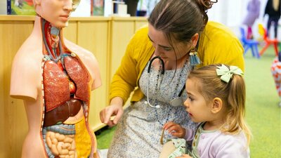 A young girl and woman exploring a human dummy A young girl and woman exploring a human dummy