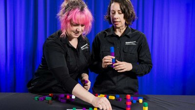 Two women explore patterns using coloured blocks