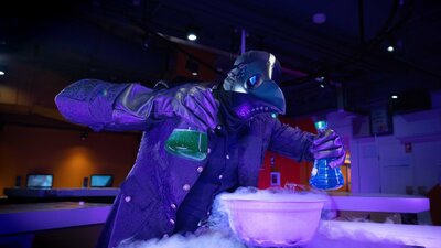 A person dressed in a Halloween Costume using liquid nitrogen in Questacon's QLab