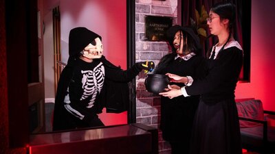 People dress in Halloween costumes standing outside Questacon's Earthquake House