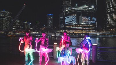 Puppeteers operate rainbow LED flamingo skeletons