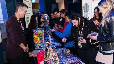 Adults choosing prizes after playing sexual health trivia with Meridian