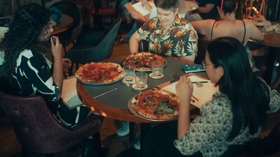 People sitting around a table eating pizza