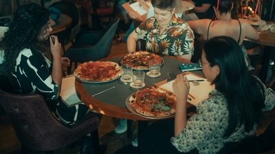 People sitting around a table eating pizza