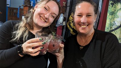 Witches drinking the cocktails they brewed themsleves. Two women smiling and drinking cocktails they brewed themselves.