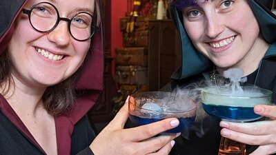 Sneaky Cauldron drinks Two witches enjoying magical mixology