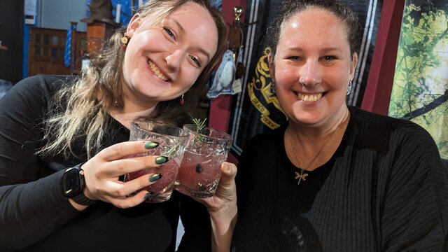 Witches drinking the cocktails they brewed themsleves. Two women smiling and drinking cocktails they brewed themselves.