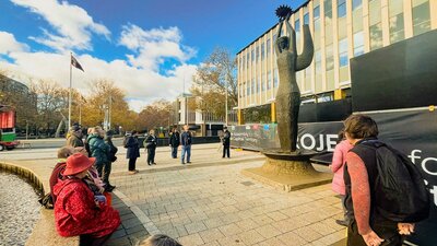 A walking tour group stands in front of the Ethos sculpture at ACT Legislative Assembly