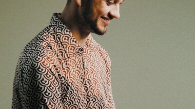 A man holding drum sticks and smiling