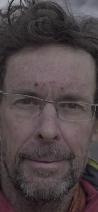 Man wearing glasses profile image with mountains in background